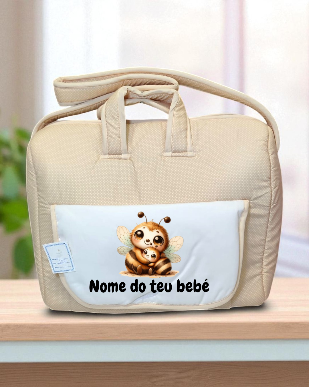Mala de bebé bege acolchoada com bolso branco e ilustração de abelhas e texto