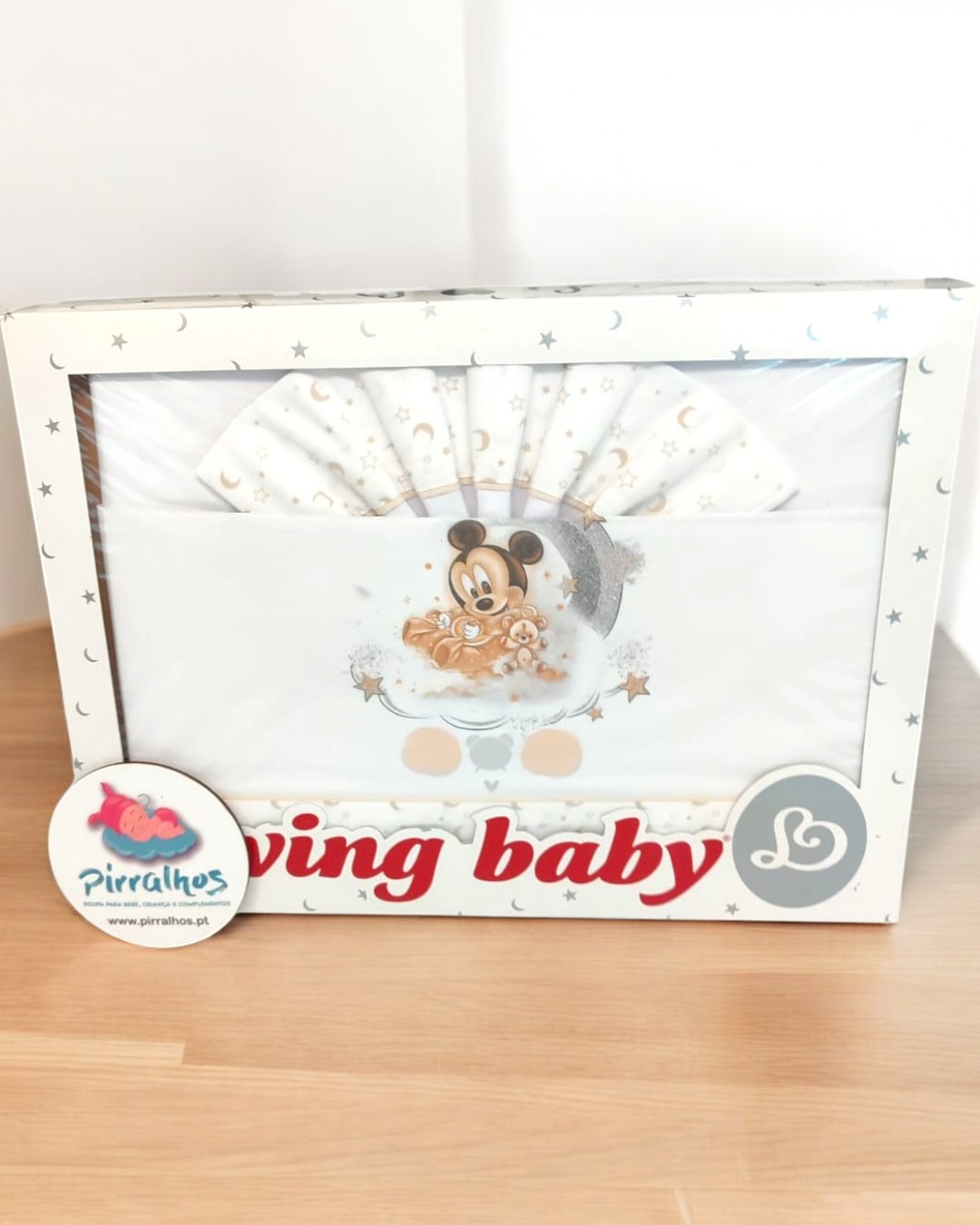 Conjunto de roupa de bebé branco com padrão de estrelas e desenho Mickey Mouse na caixa