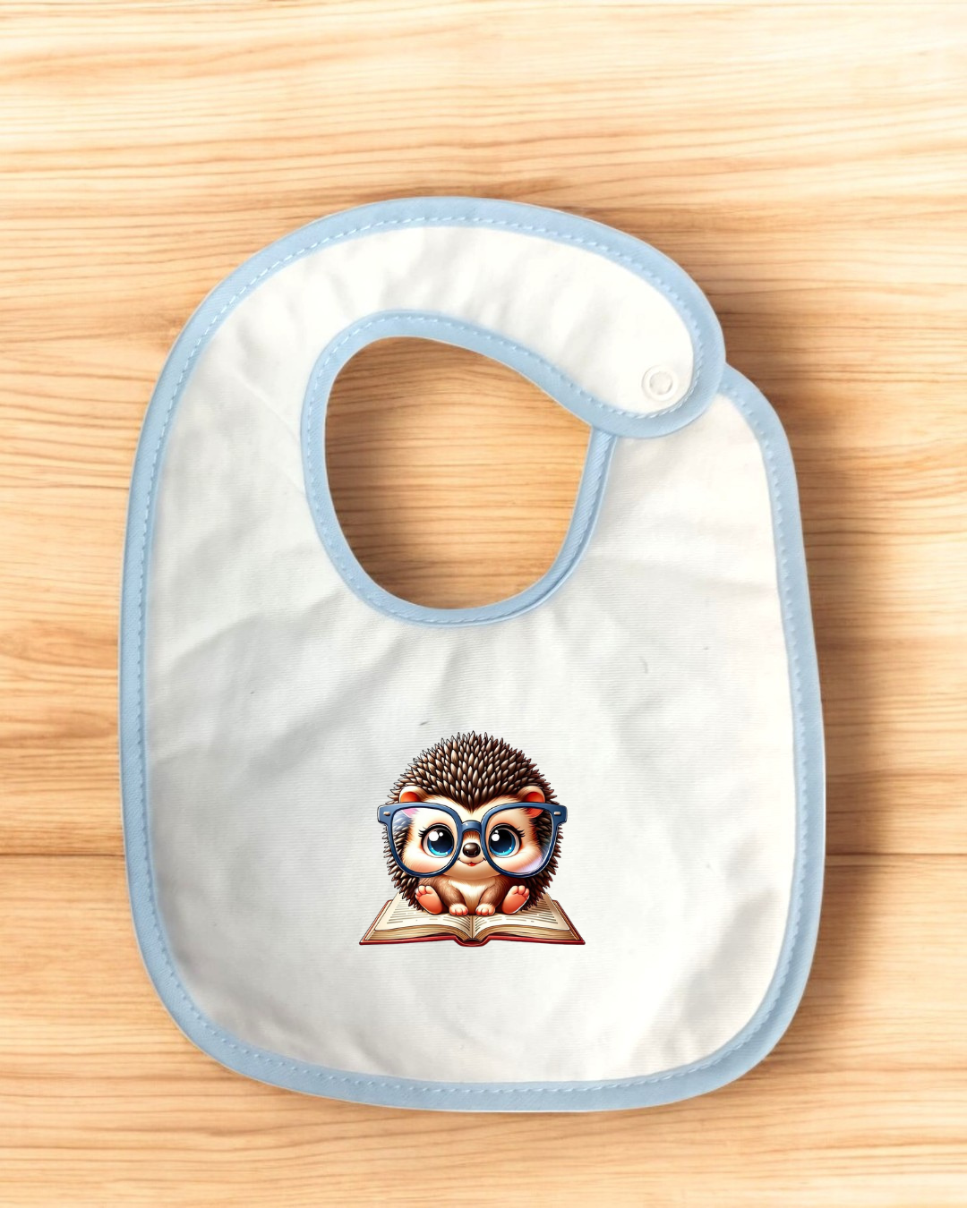 Babete branco com estampa de ouriço de óculos em fundo de madeira