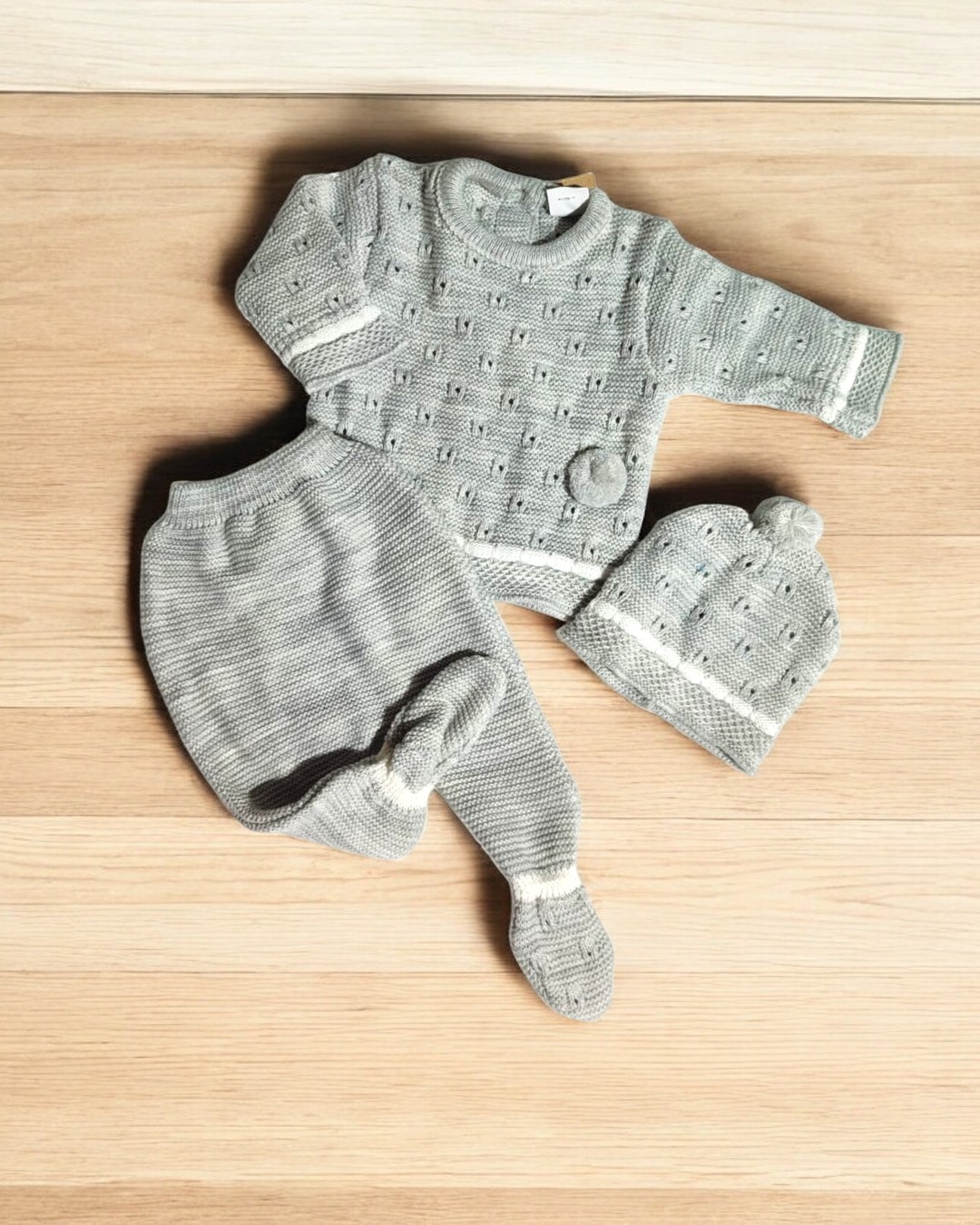 Conjunto de roupa de bebé em malha cinza claro com camisola, calças e gorro com pompom