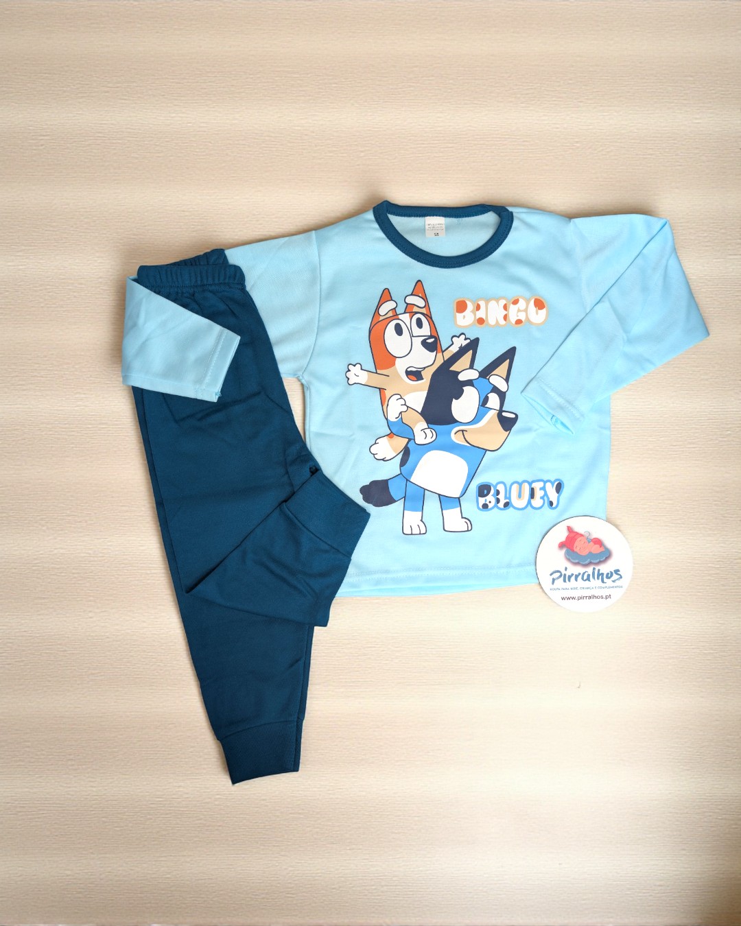 Pijama infantil azul com estampa dos cães Bingo e Bluey e etiqueta Pirralhos