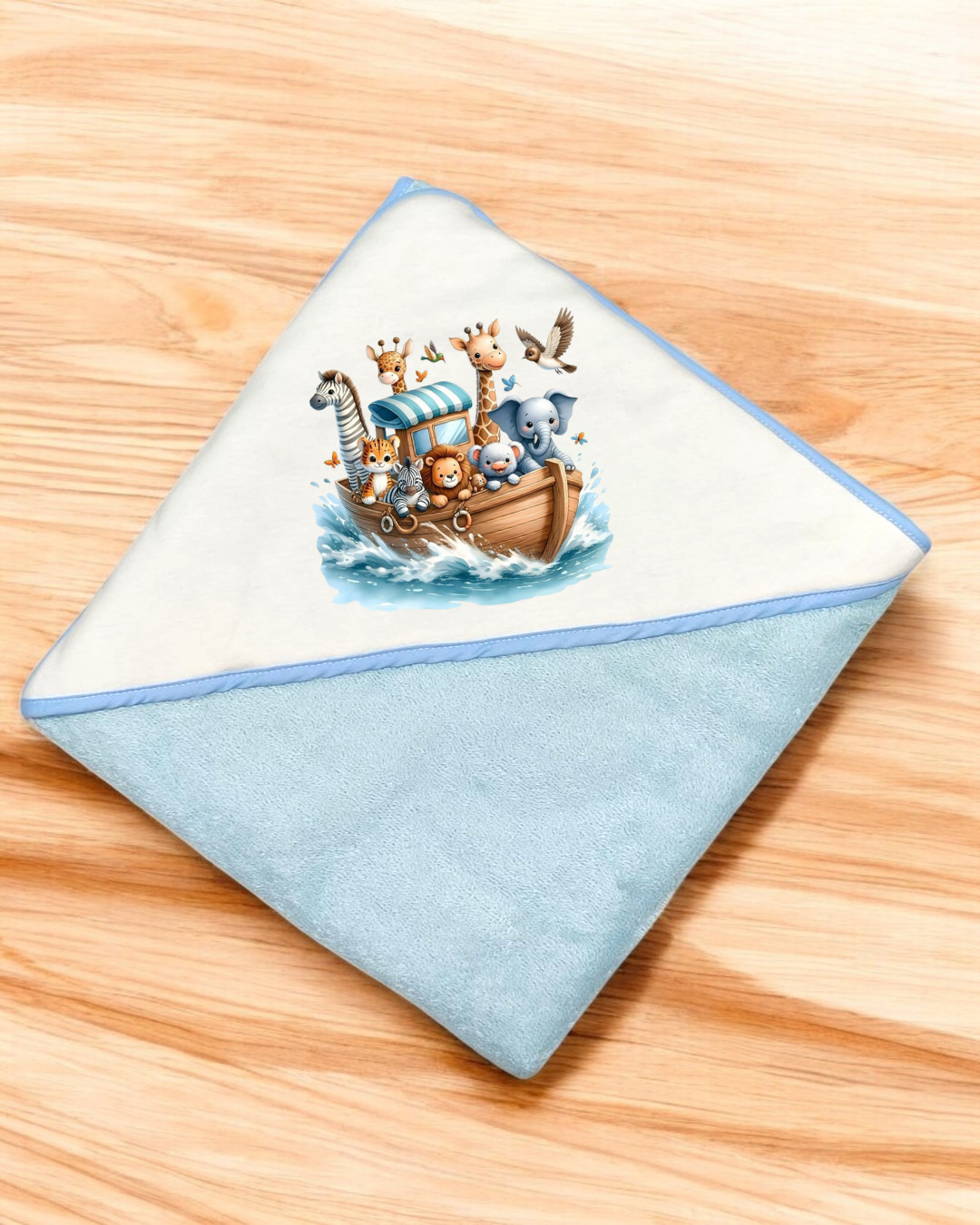 Toalha de bebé azul e branca com desenho de barco e animais