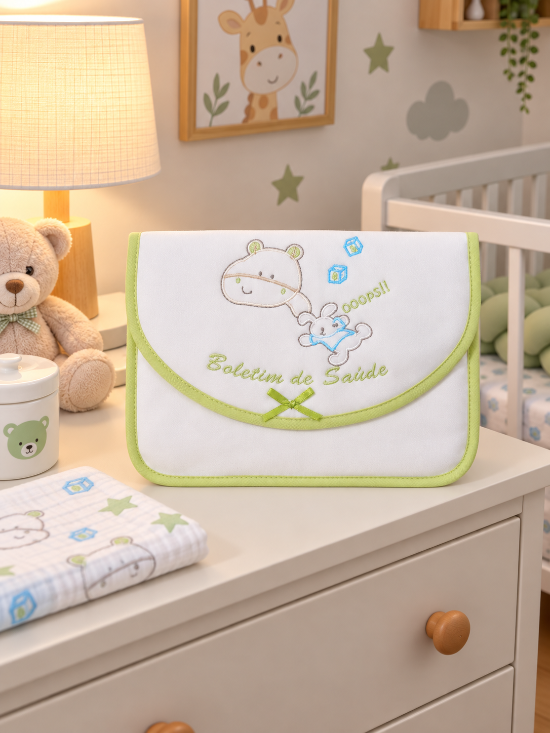 Estojo branco com bordado de urso e coelho, contorno verde, texto Boletim de Safade, num quarto infantil