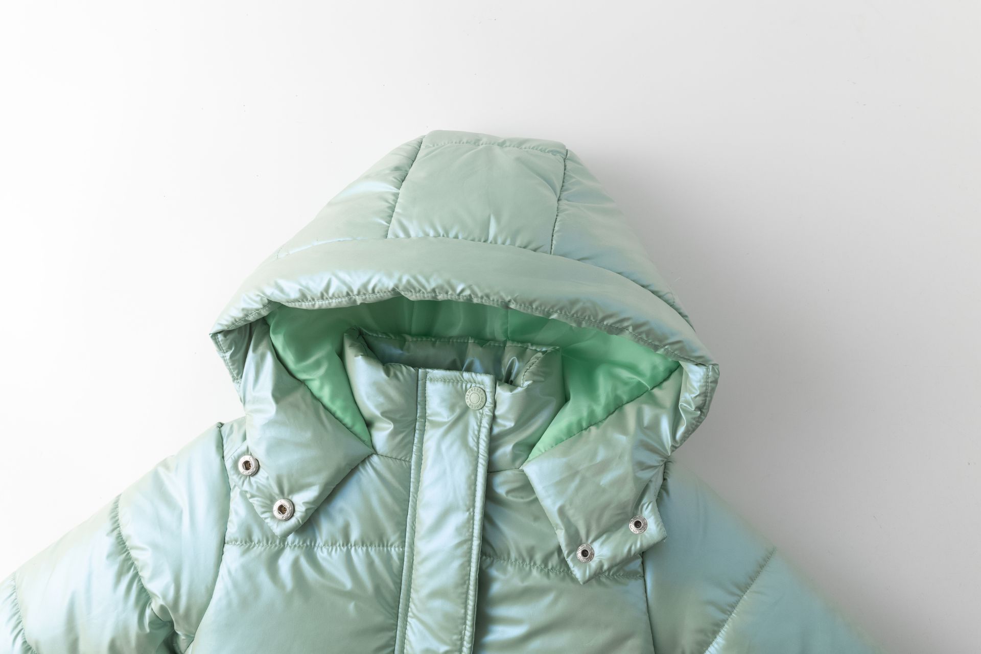 Casaco acolchoado verde água com capuz e costuras horizontais