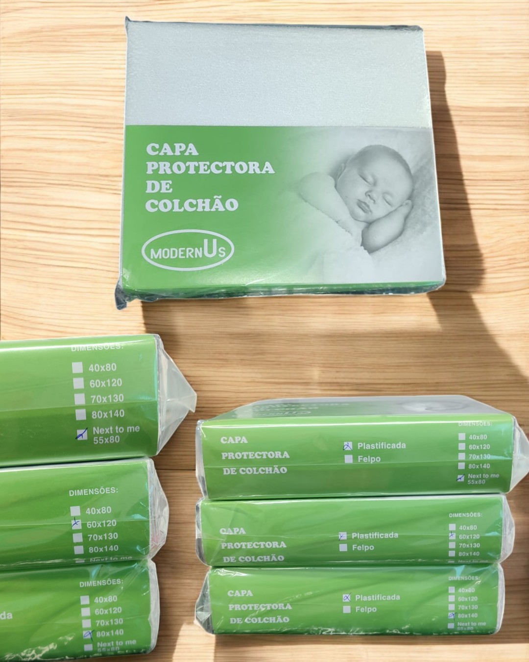 Embalagens de capas protetoras de colchão MODERNUS em tons verde e branco com imagem de bebé