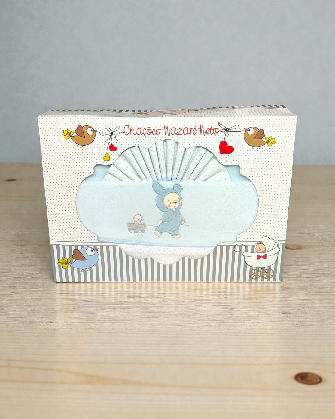Caixa de presente com toalha azul clara para bebé e tecido branco com pontos azuis