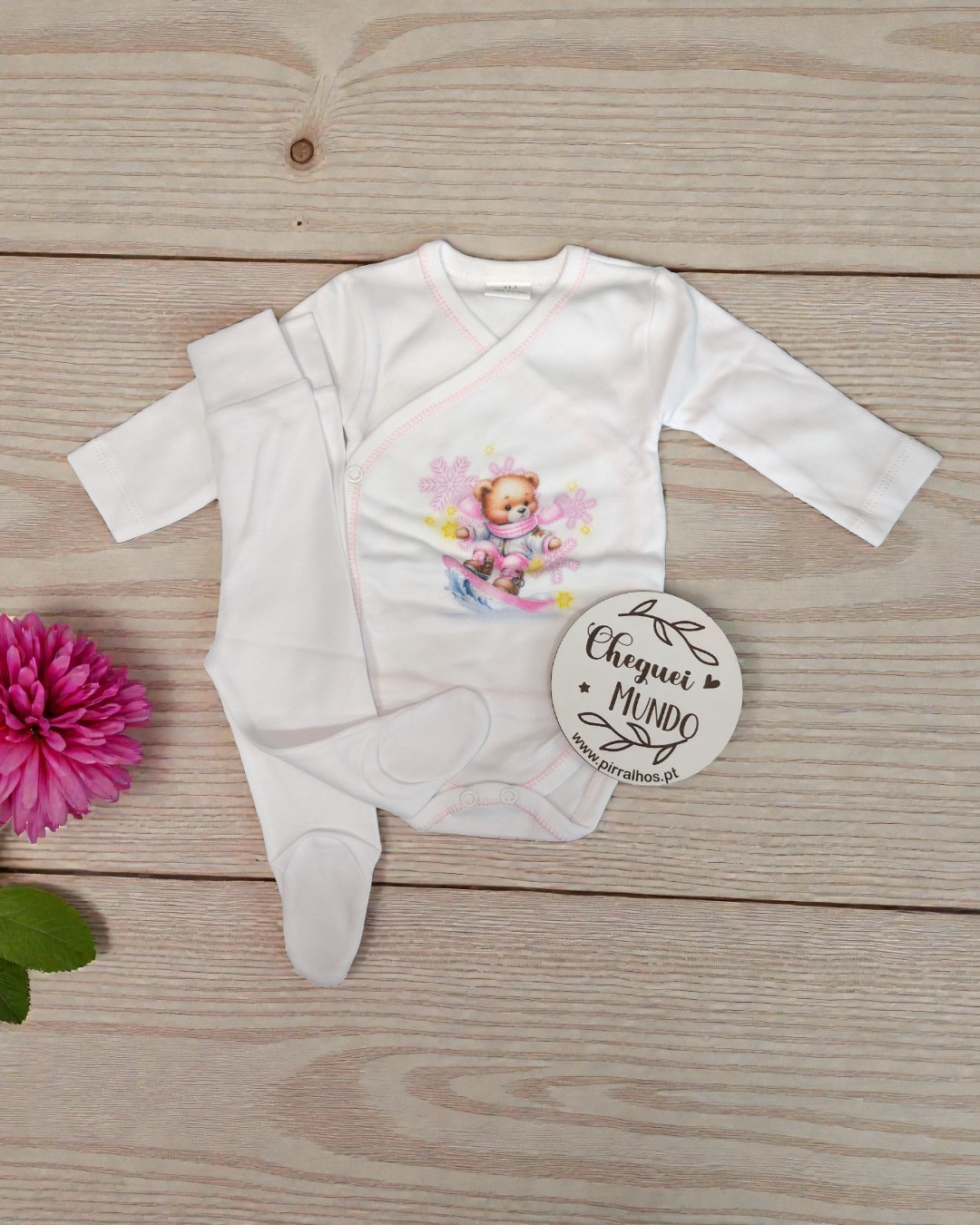 Conjunto roupa bebé branco com ursinho e pézinhos sobre fundo madeira clara