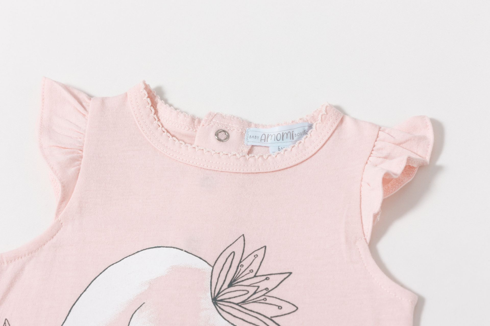 Roupa de bebé cor-de-rosa com mangas de folho e botão metálico na gola