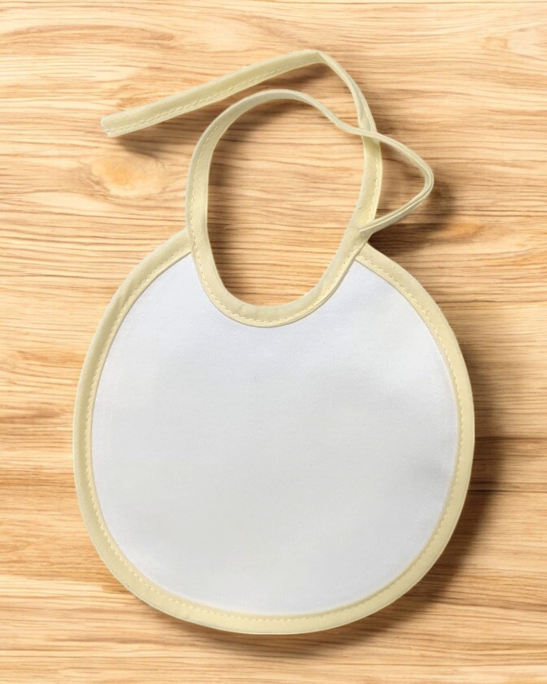 Babete branco com bordas bege sobre madeira clara