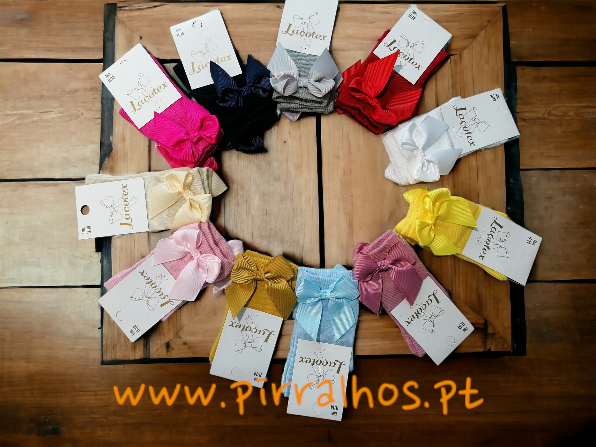 Faixas para cabelo coloridas com laços dispostas em círculo com etiqueta Lacotex sobre madeira