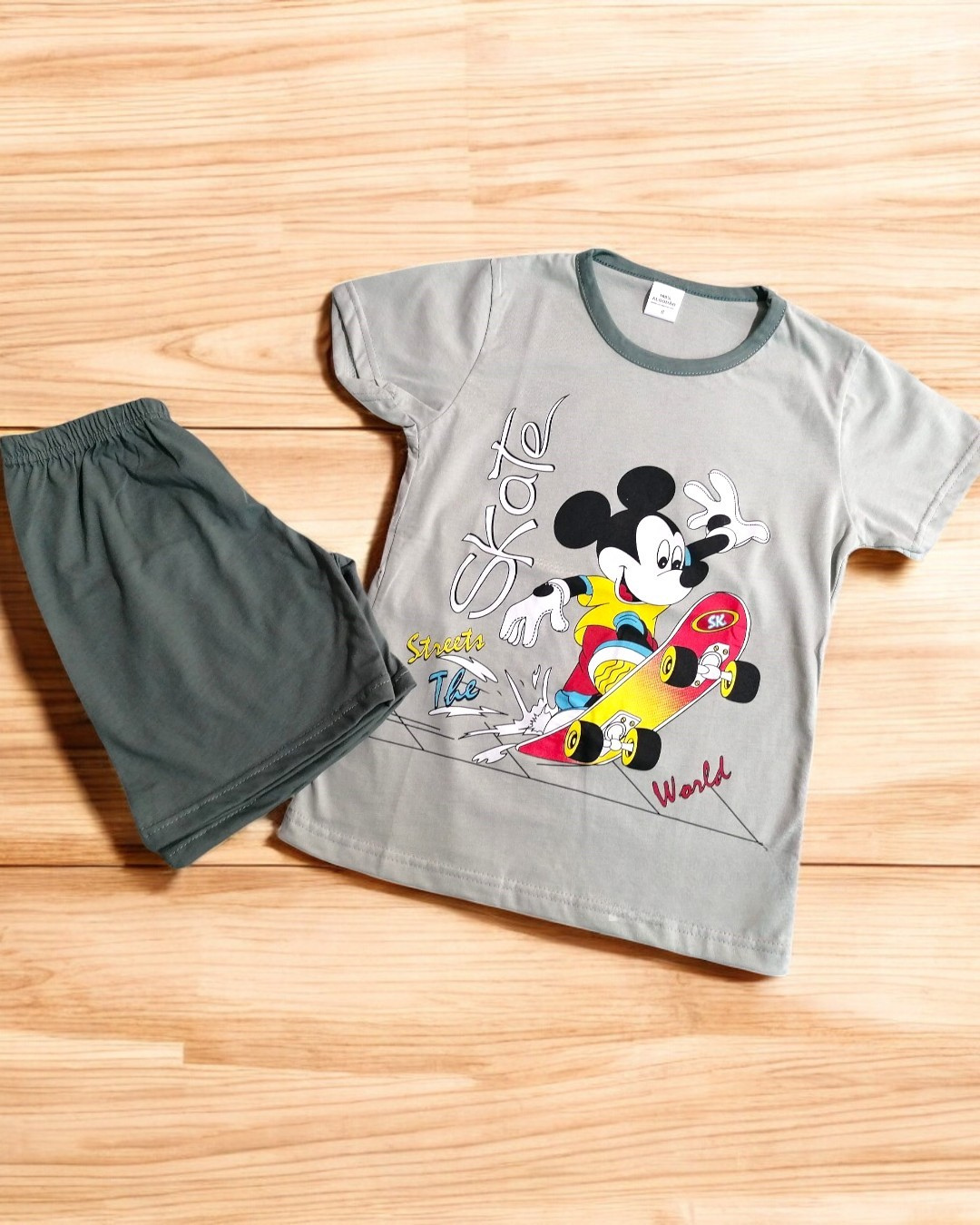 Conjunto infantil de t-shirt cinza com estampa de Mickey Mouse a andar de skate e calções verdes escuros