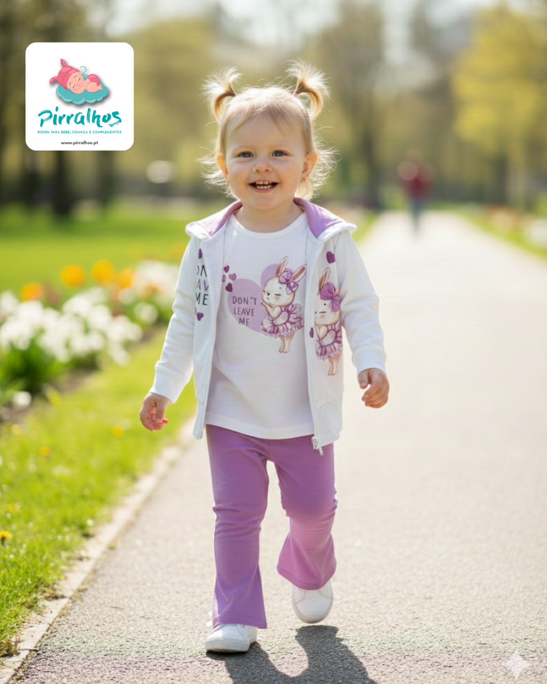 Criança a caminhar em parque com roupa branca e lilás e desenhos de coelhinha bailarina