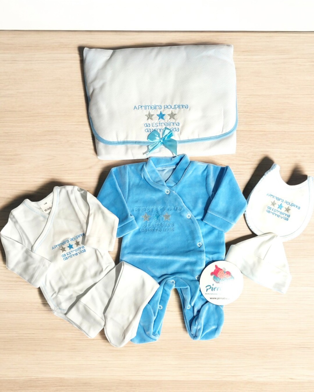 Conjunto de roupa de bebé com manta, babete, gorro e dois macacões em branco e azul