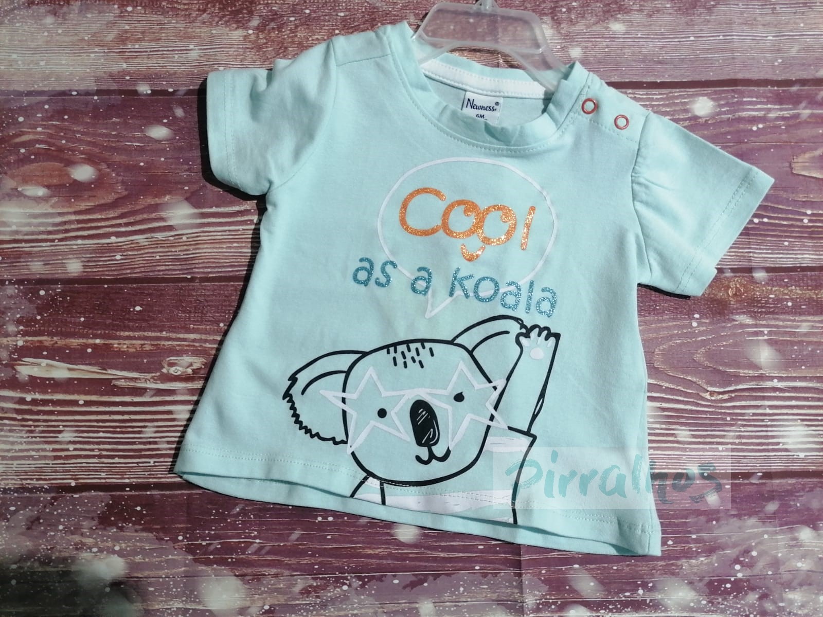 Camisola azul clara de bebé com desenho de coala e texto em madeira
