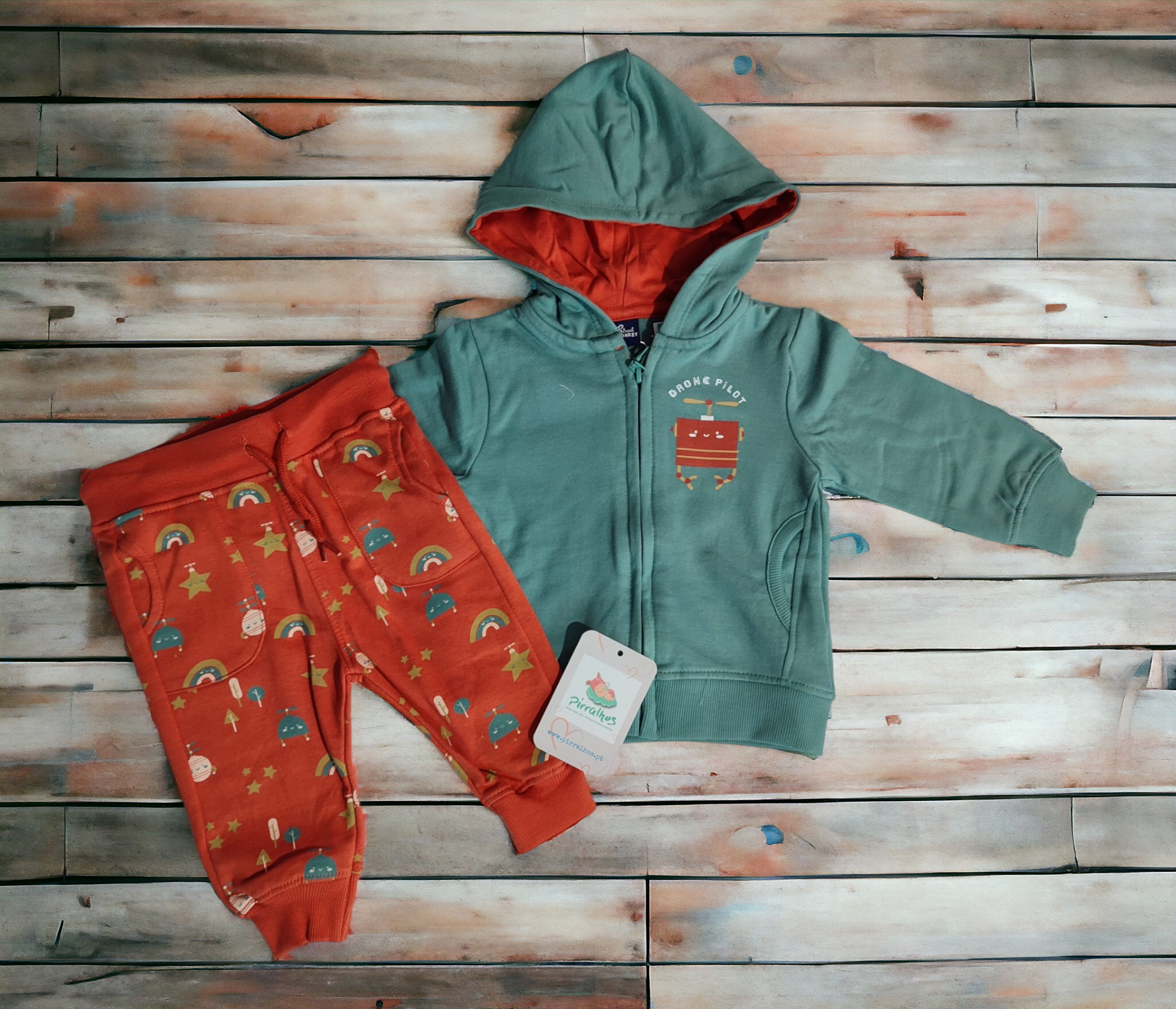 Conjunto infantil com casaco verde e calças laranja com padrões coloridos