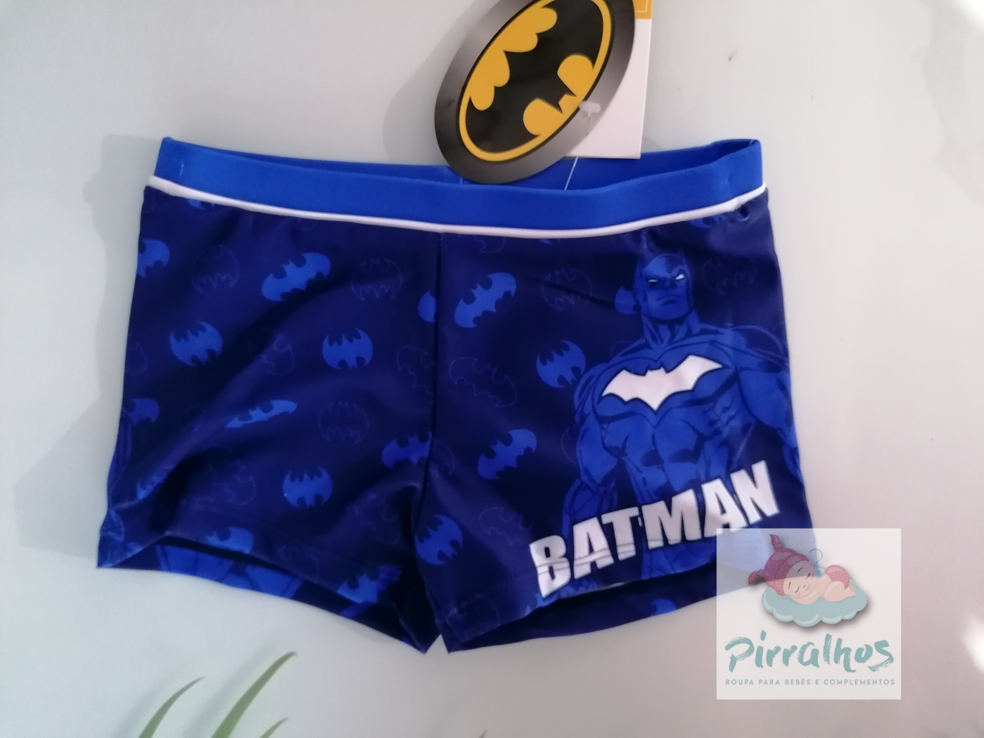 Calções de banho azuis com estampa do Batman e logótipo em fundo branco