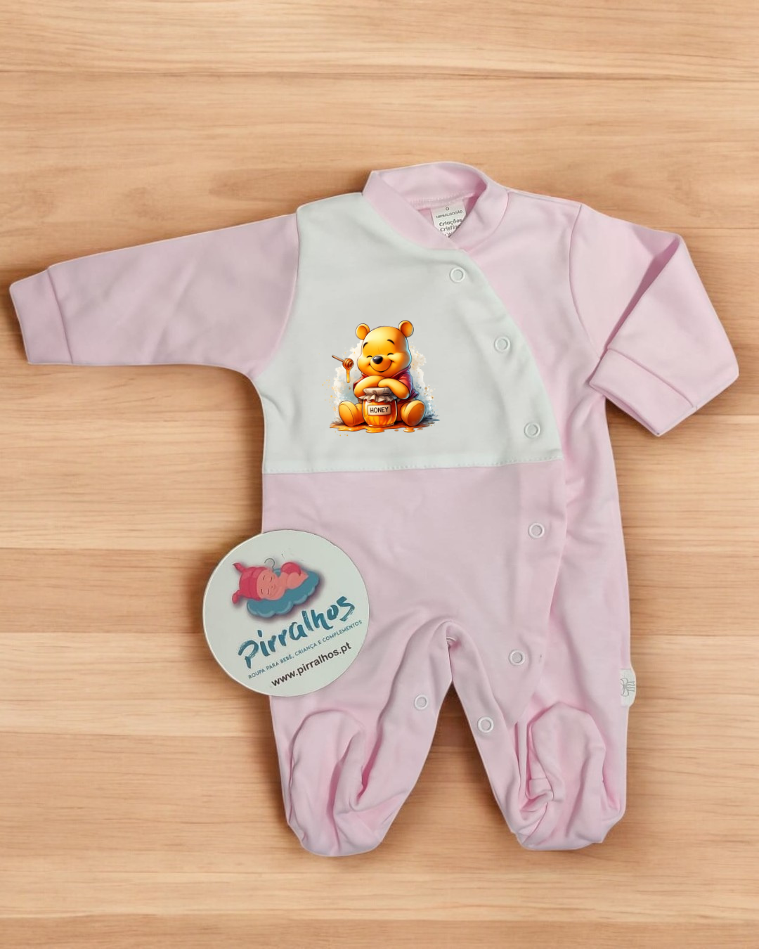 Macacão de bebé cor-de-rosa e branco com desenho de urso a segurar pote de mel