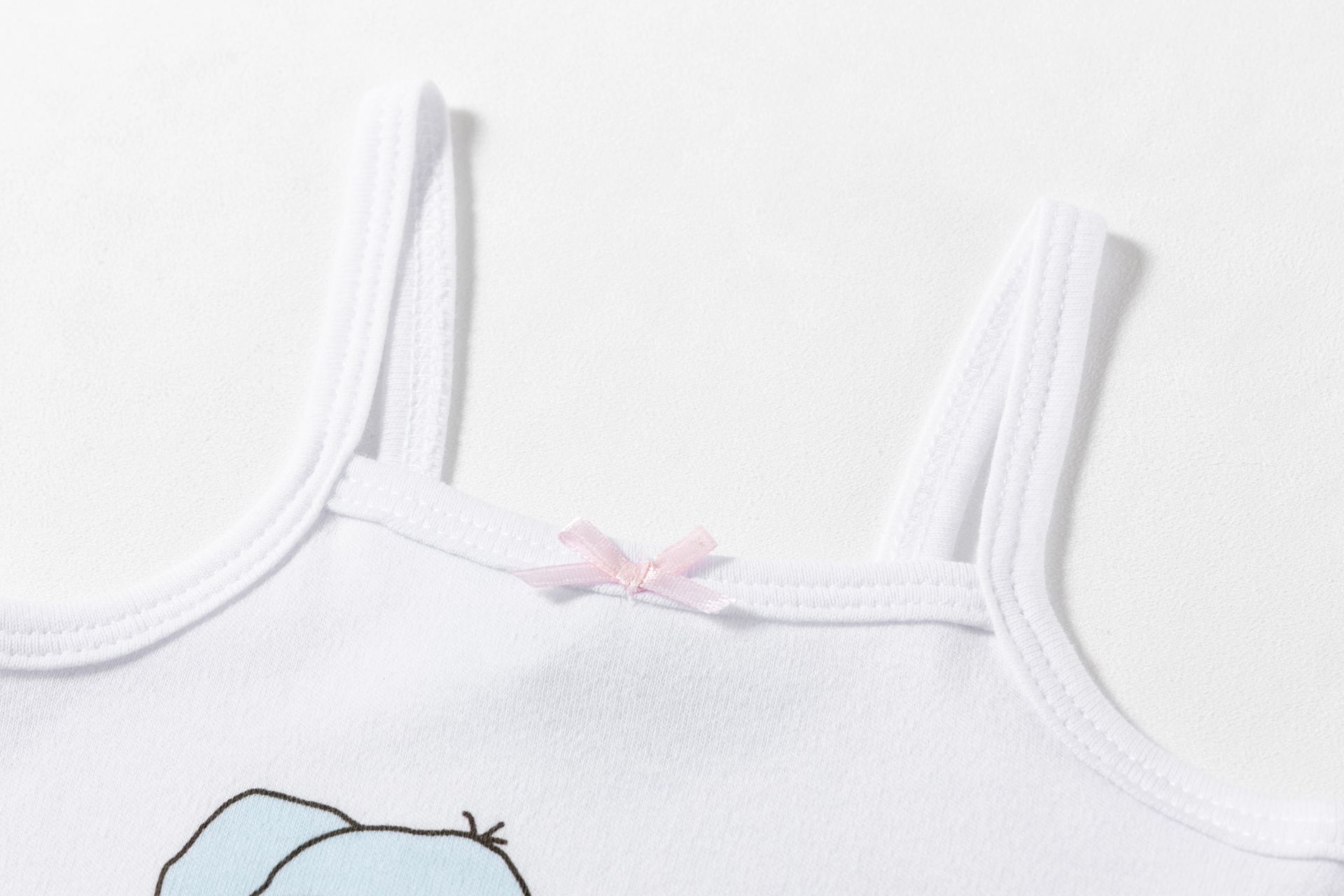 Camisola de alças finas branca com pequeno laço cor-de-rosa.