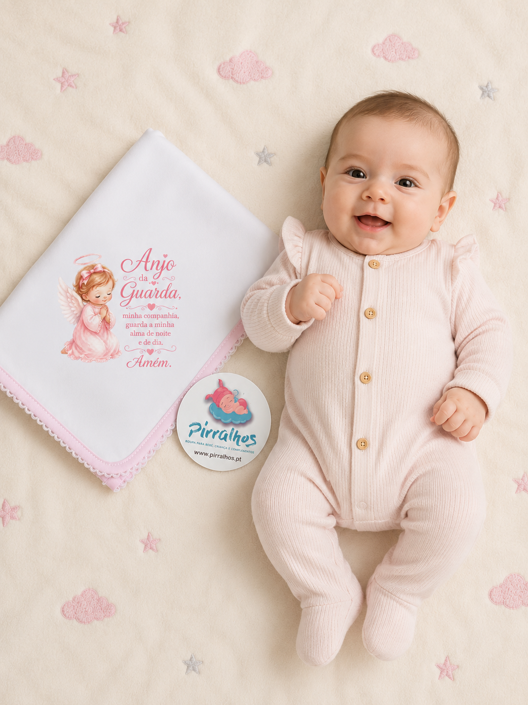 Bebé com macacão rosa claro de malha e fralda branca com mensagem em fundo creme bordado
