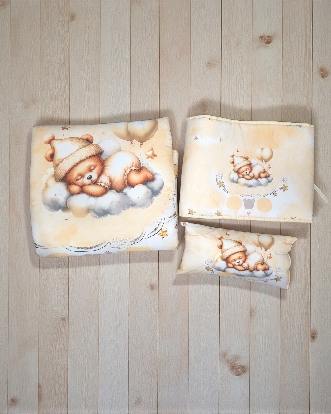 Três peças têxteis infantis bege com ursinho a dormir numa nuvem e balões