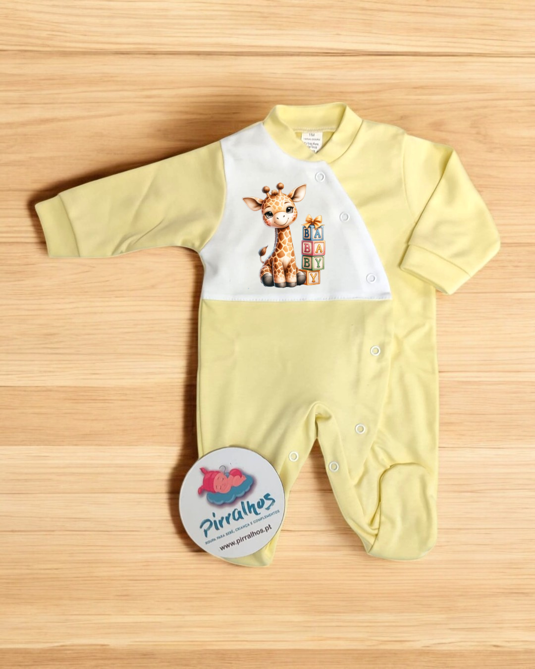 Pijama de bebé amarelo com estampa de girafa e palavras BABY