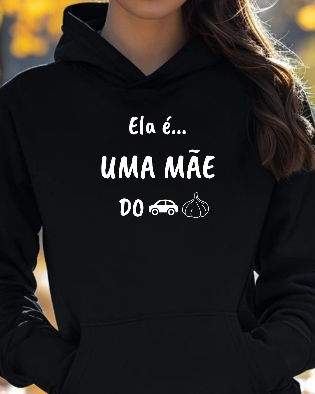 Sweatshirt preta com texto e ícones brancos, usada por pessoa em fundo outonal