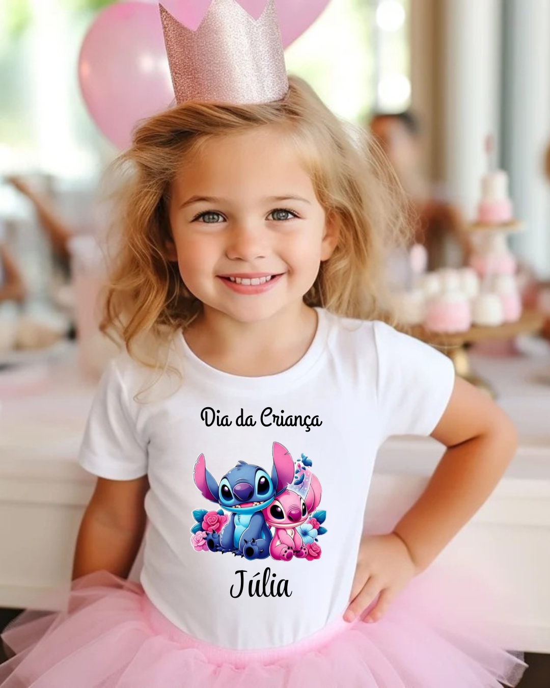 Menina sorridente com camisola branca estampada, saia rosa e coroa em festa