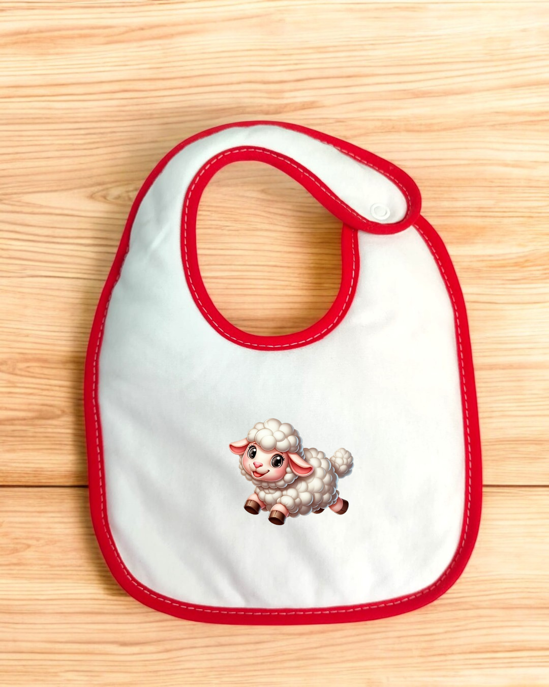 Babete branco com borda vermelha e ovelha desenhada no centro