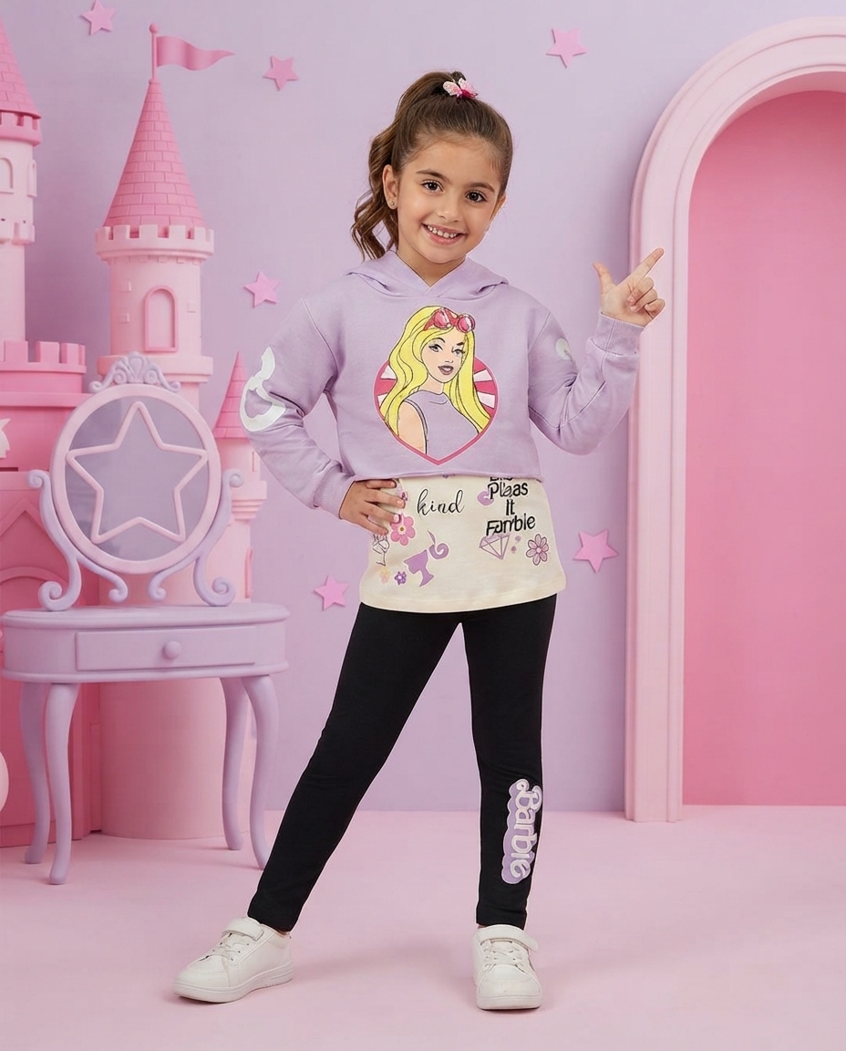 Menina com hoodie lilás, calças pretas com texto Barbie e ténis brancos em cenário rosa com castelo e cadeira decorativa.