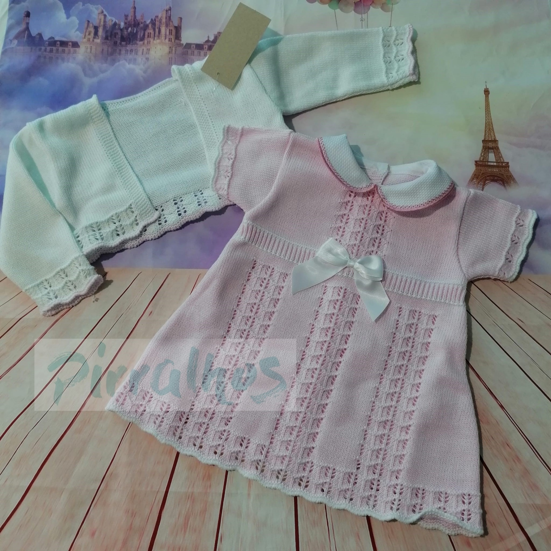 Vestido rosa de bebé com laço branco e cardigã branco de malha