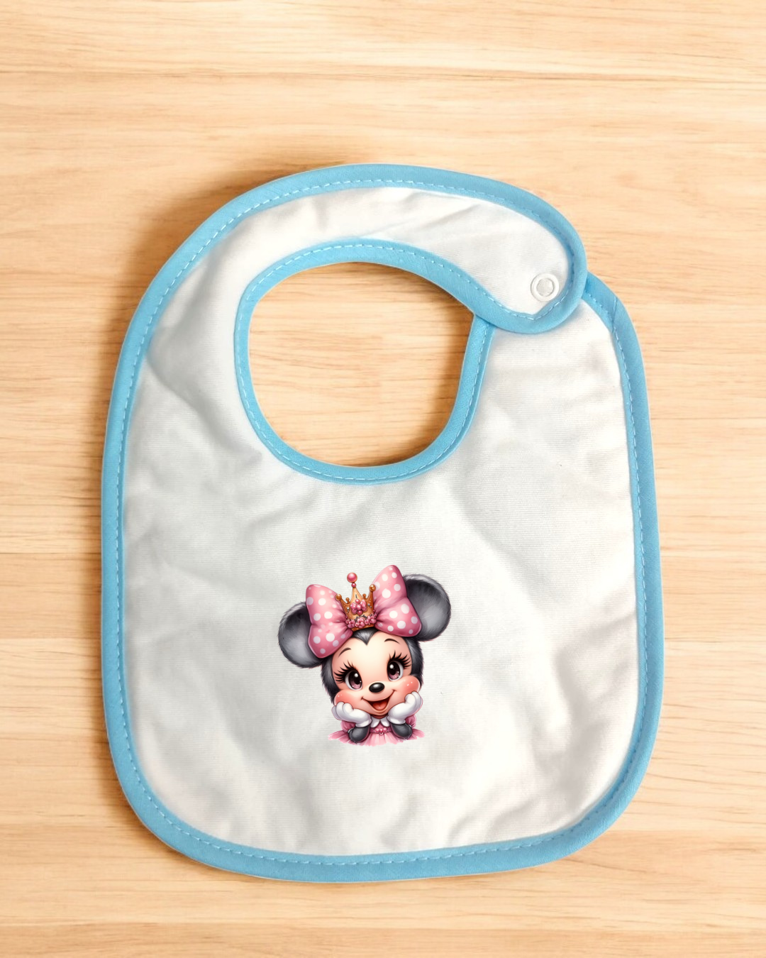 Babete branco com bordas azuis e personagem Minnie Mouse no centro
