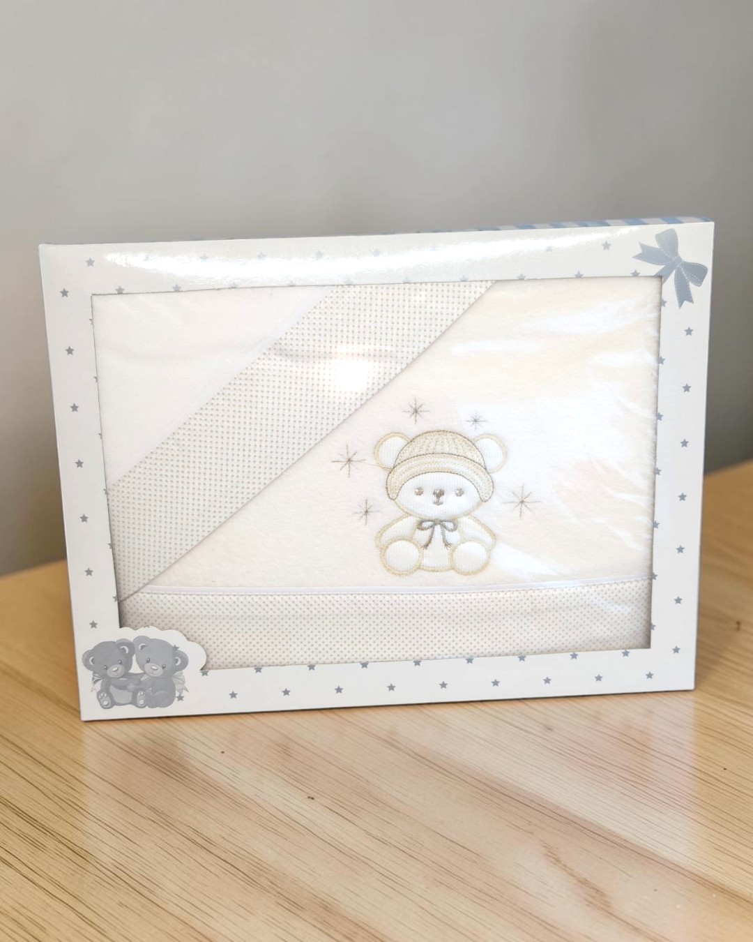 Toalha de bebé branca com bordado de ursinho em caixa com estrelas cinzentas