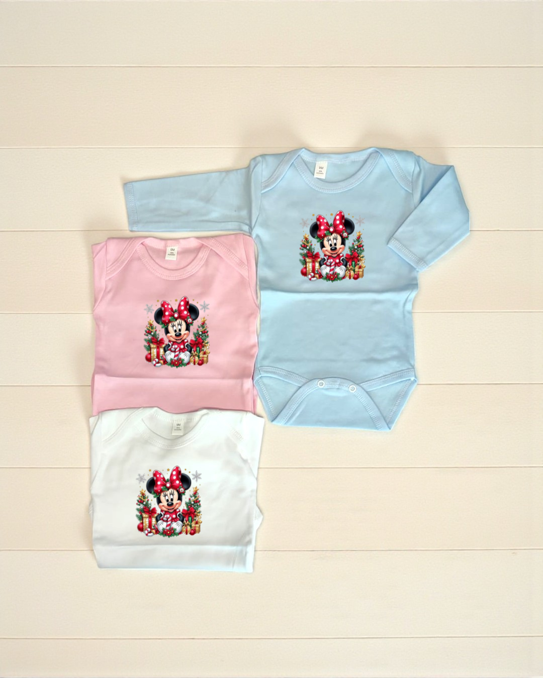 Bodies de bebé azul claro, rosa e branco com desenho de Minnie Mouse natalícia.