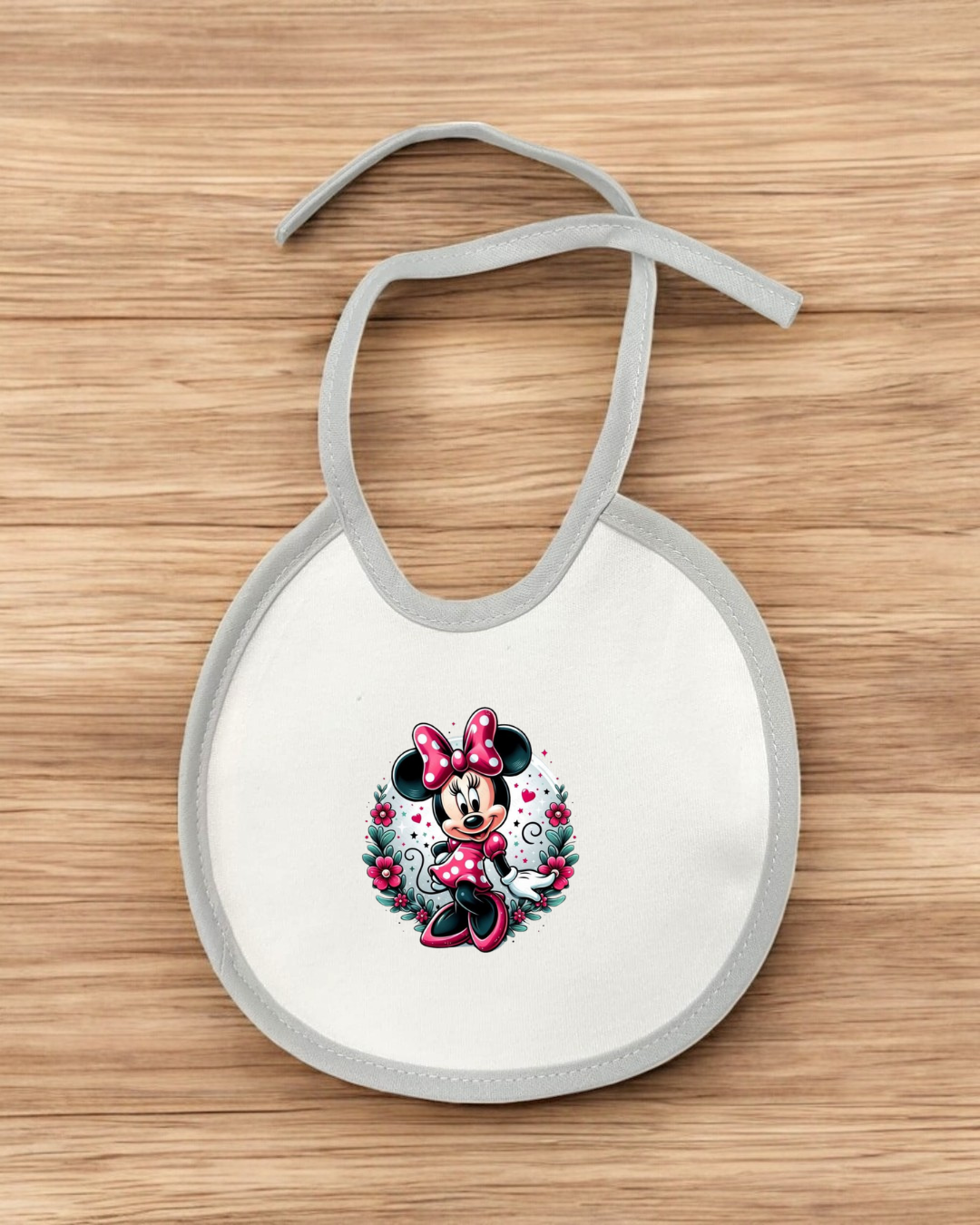 Babete branco com borda cinza e imagem da Minnie Mouse em vermelho.