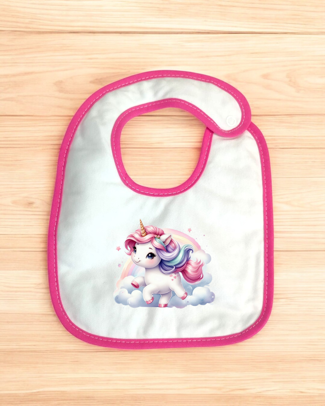Babete de bebé branco com bordas cor-de-rosa e desenho de unicórnio colorido