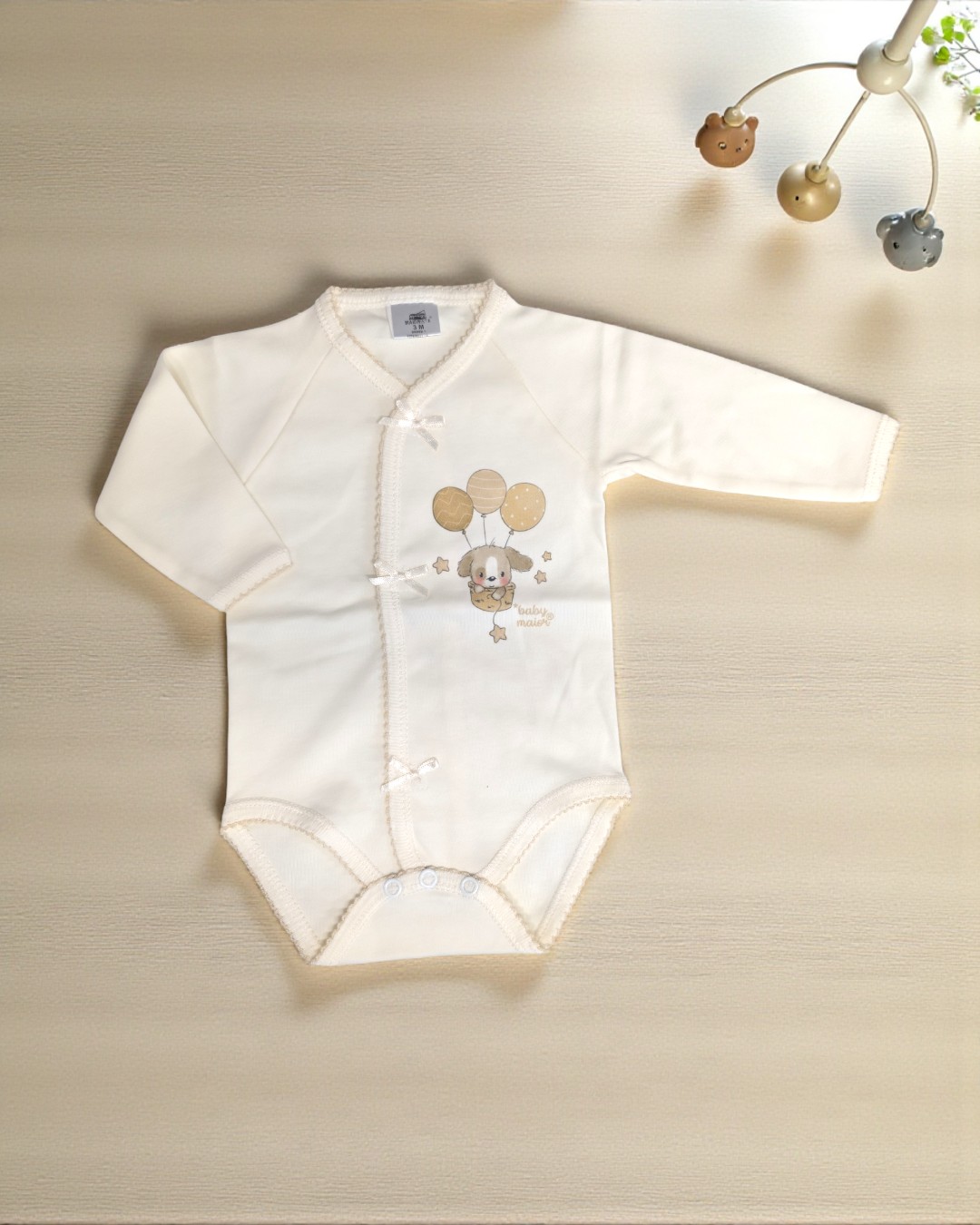 Body branco de manga comprida para bebé com estampa de cão e balões em bege.