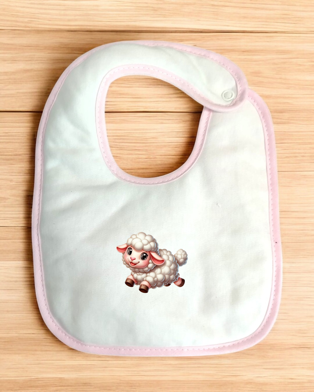 Babete branco com borda rosa e estampa de ovelha em madeira clara