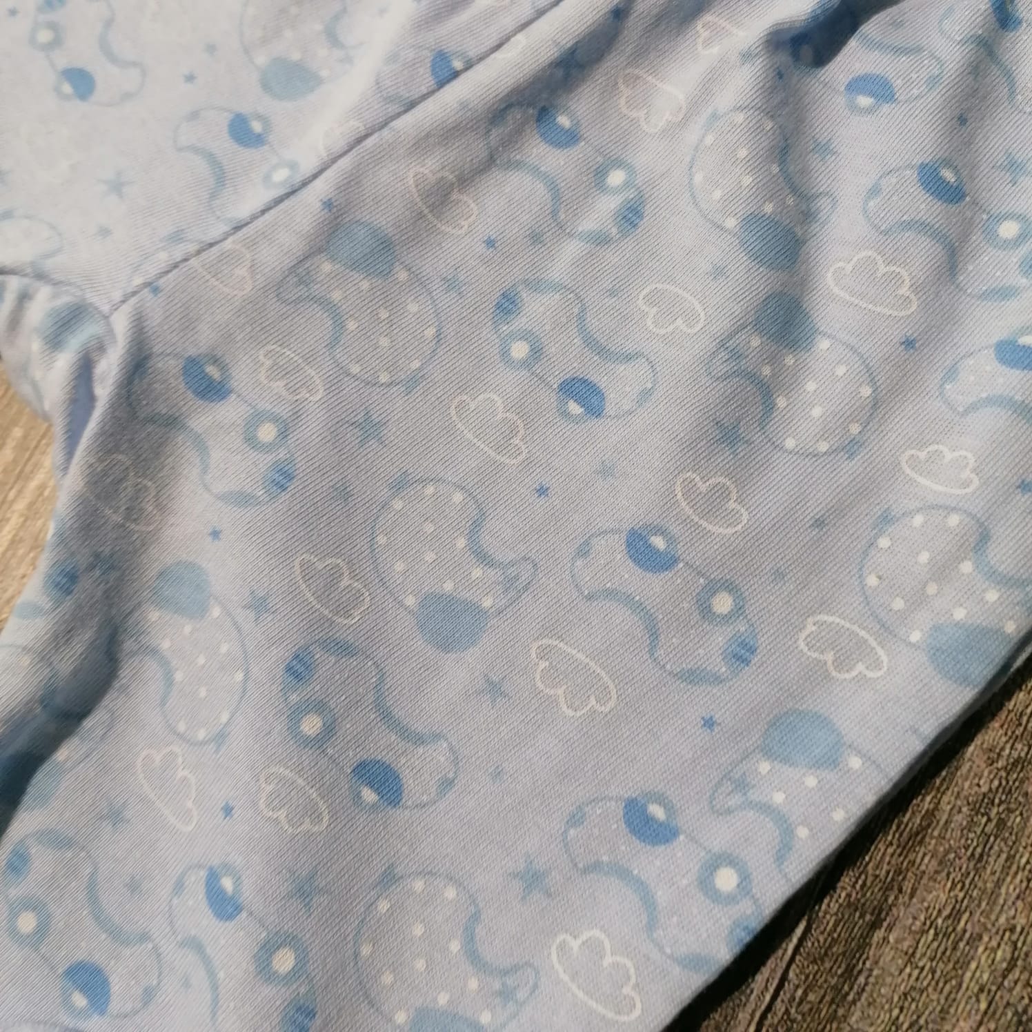 tecido azul claro com padrão de elefantes, nuvens e estrelas