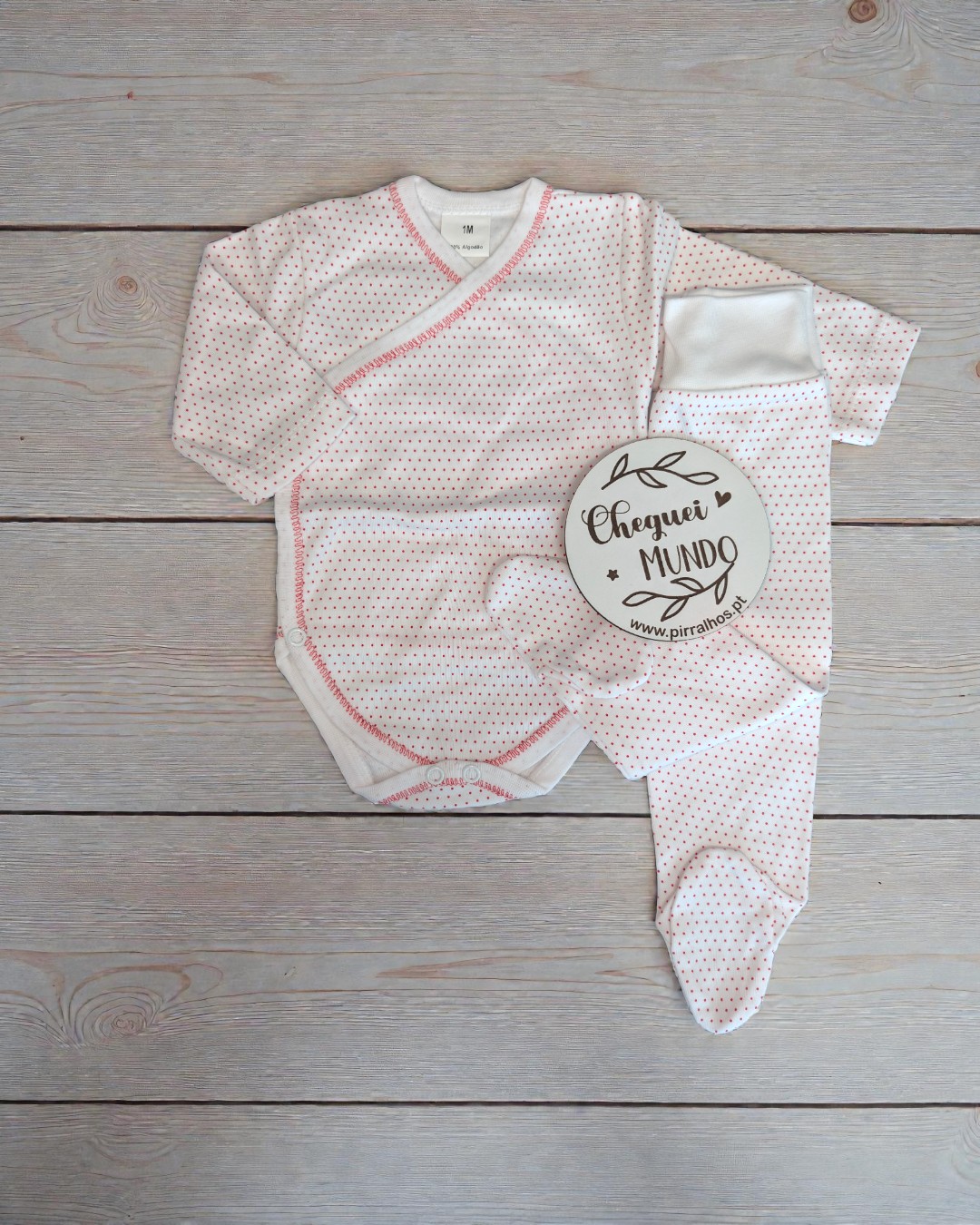 Conjunto de roupa de bebé branco com pontos vermelhos e etiqueta redonda