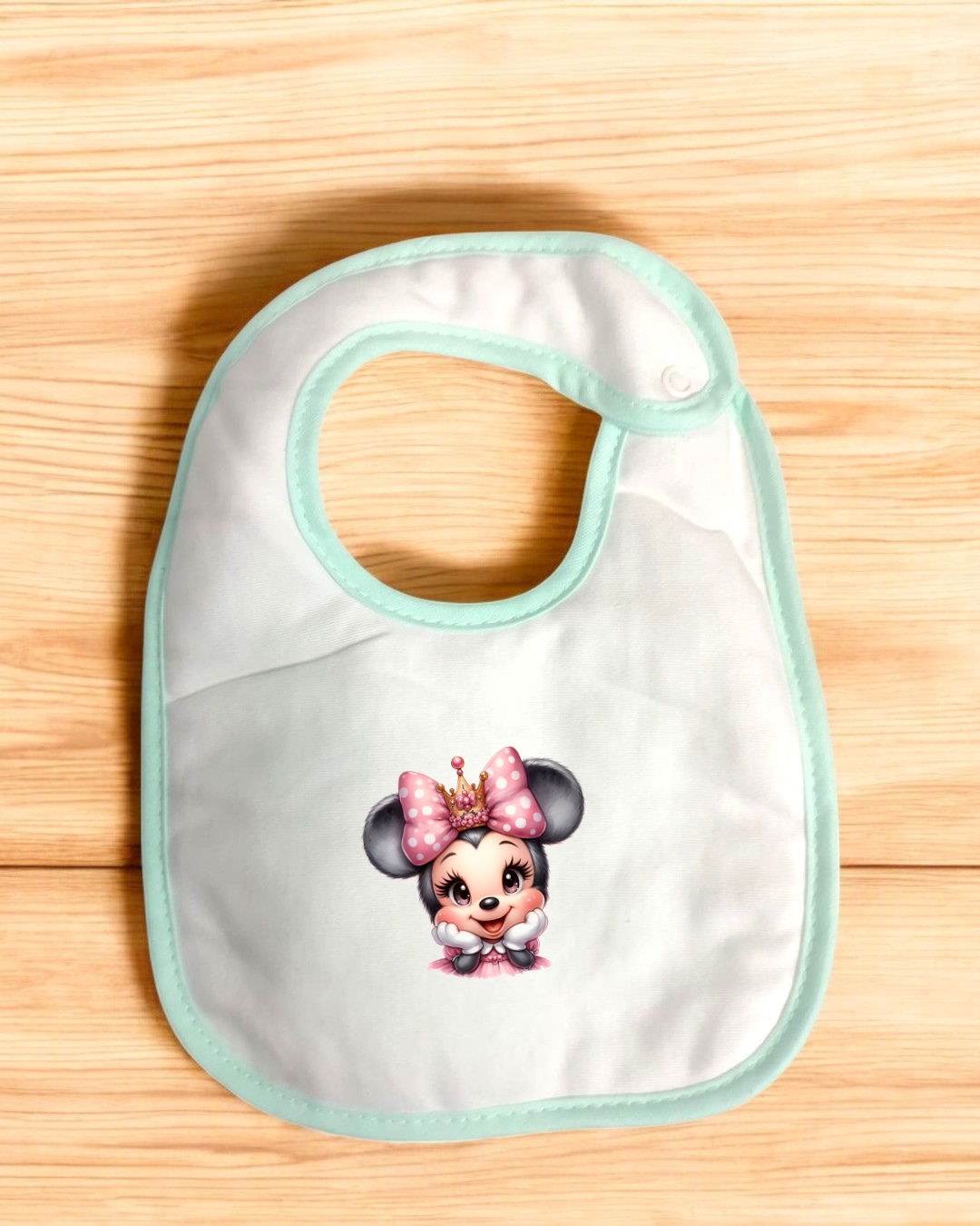 Babete branco com bordas verde água e personagem animado com laço rosa