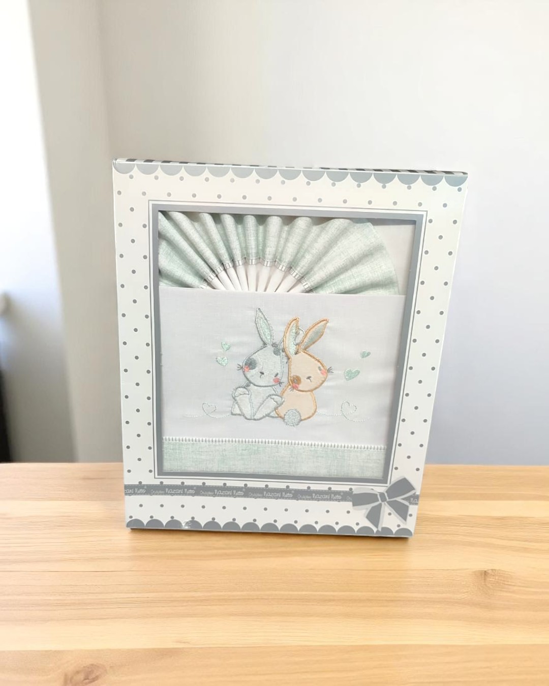 Conjunto de roupa de bebé com bordado de coelhinhos em caixa decorada