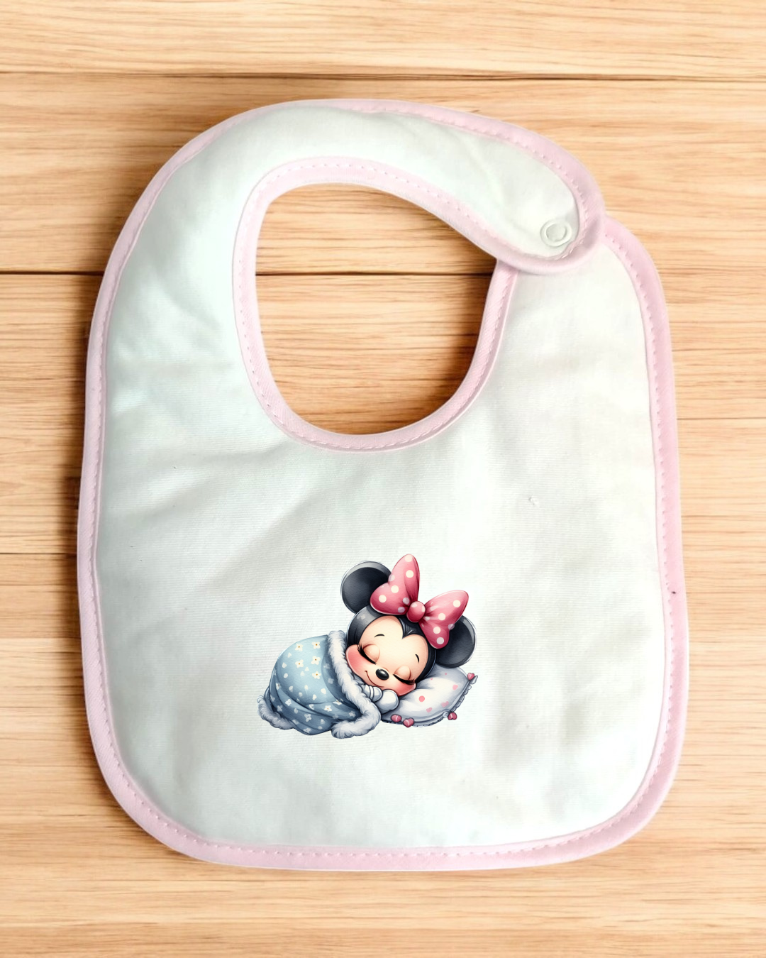 Babete branco com bordas rosa e imagem da Minnie Mouse a dormir