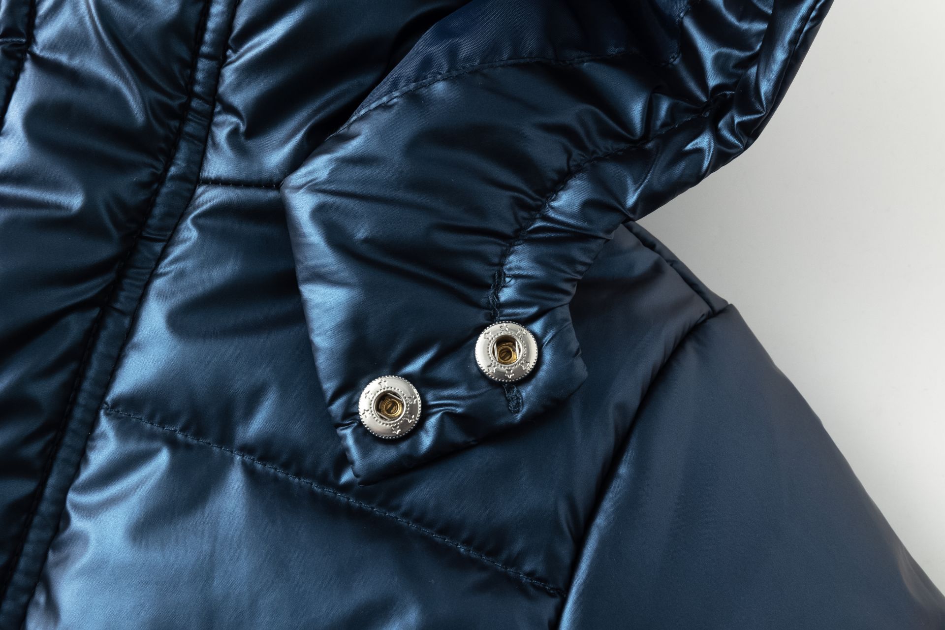 Casaco acolchoado azul escuro com botões metálicos
