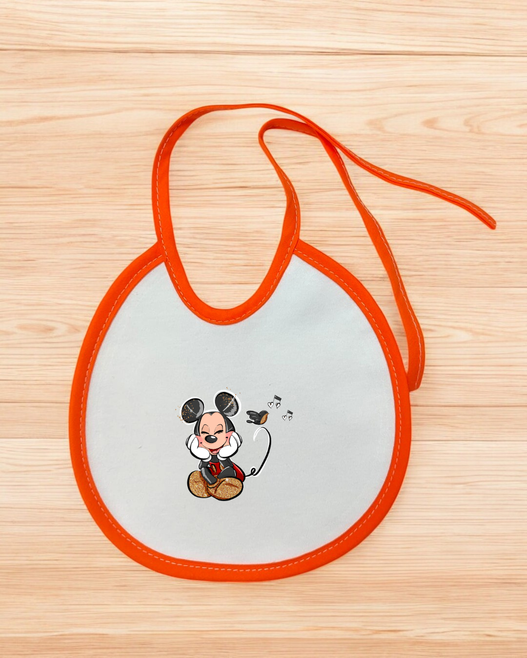 Babete branco com bordas laranja e ilustracao do Mickey Mouse