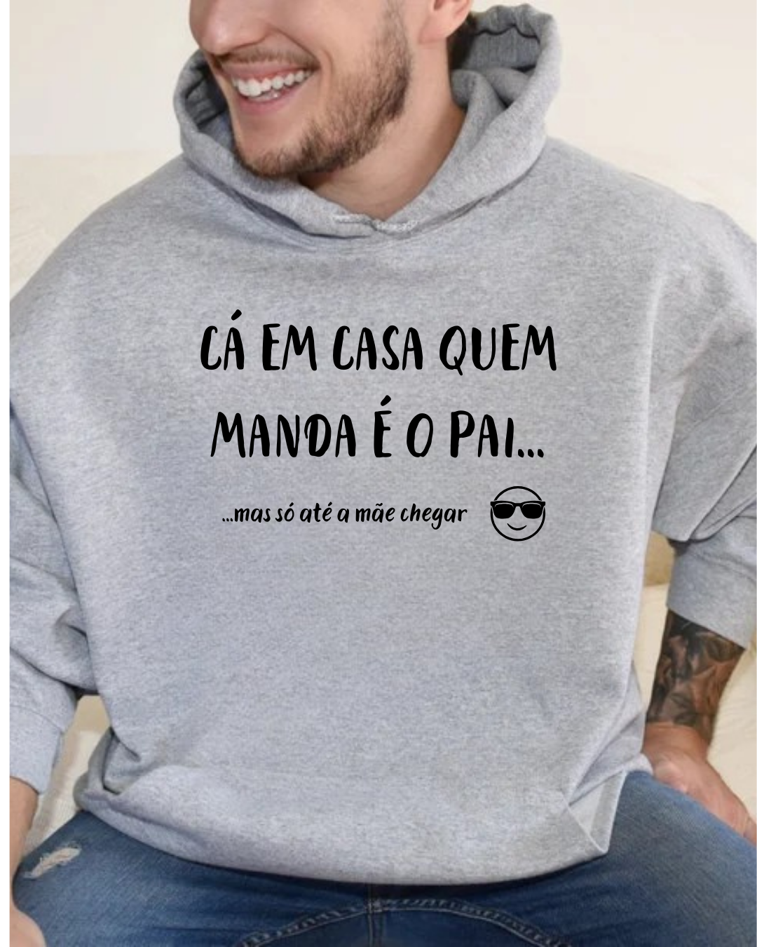 Sweatshirt cinzenta com texto preto humorístico e emoji, homem sentado a usar