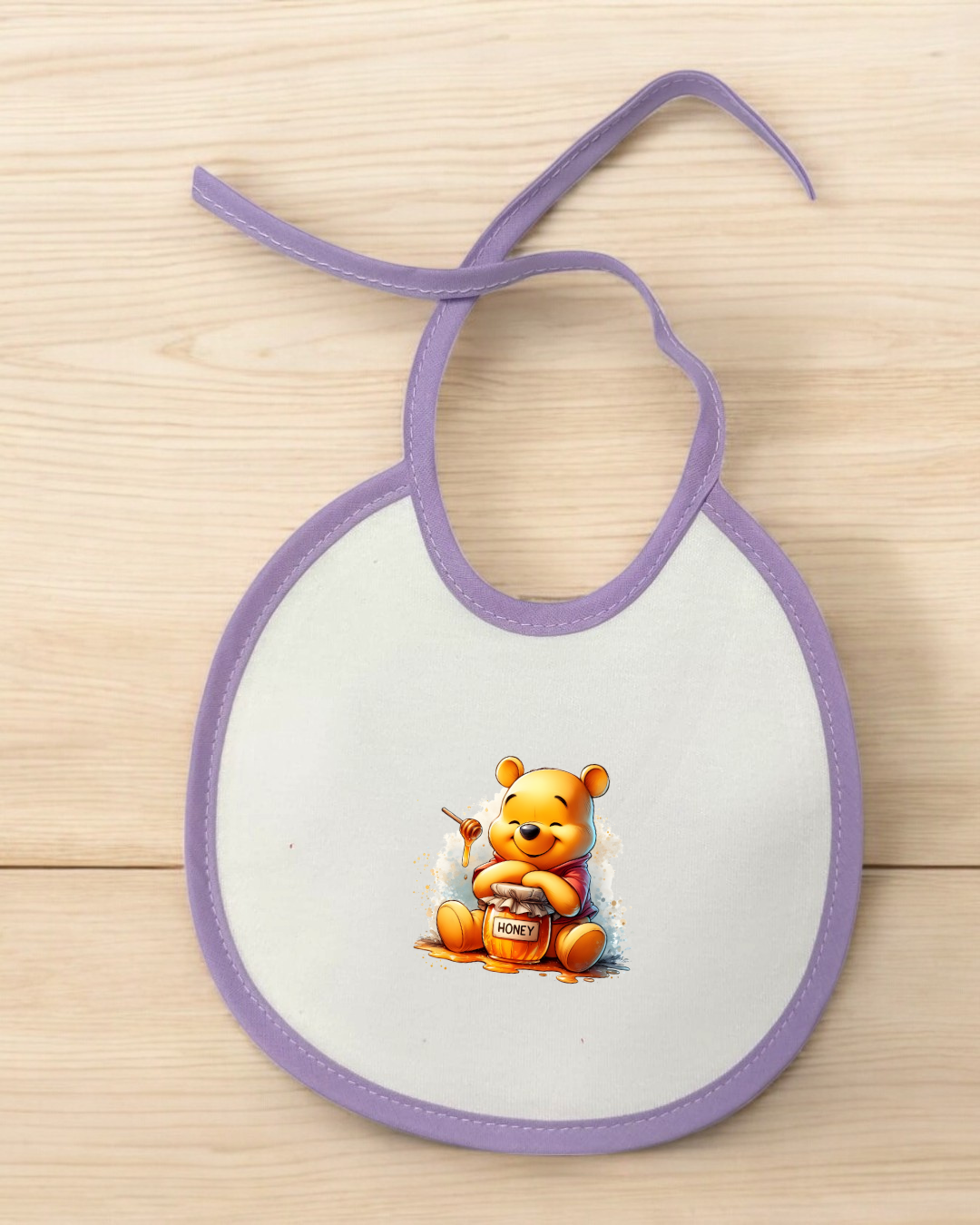 Babete branco com bordas roxas e estampa do urso Winnie the Pooh