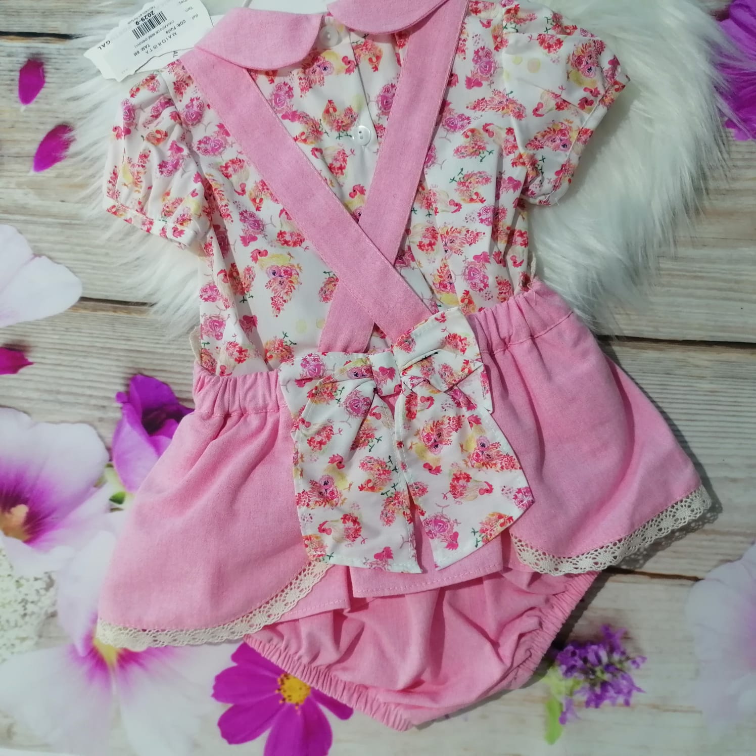 Body de bebé rosa com padrão floral e saia rosa