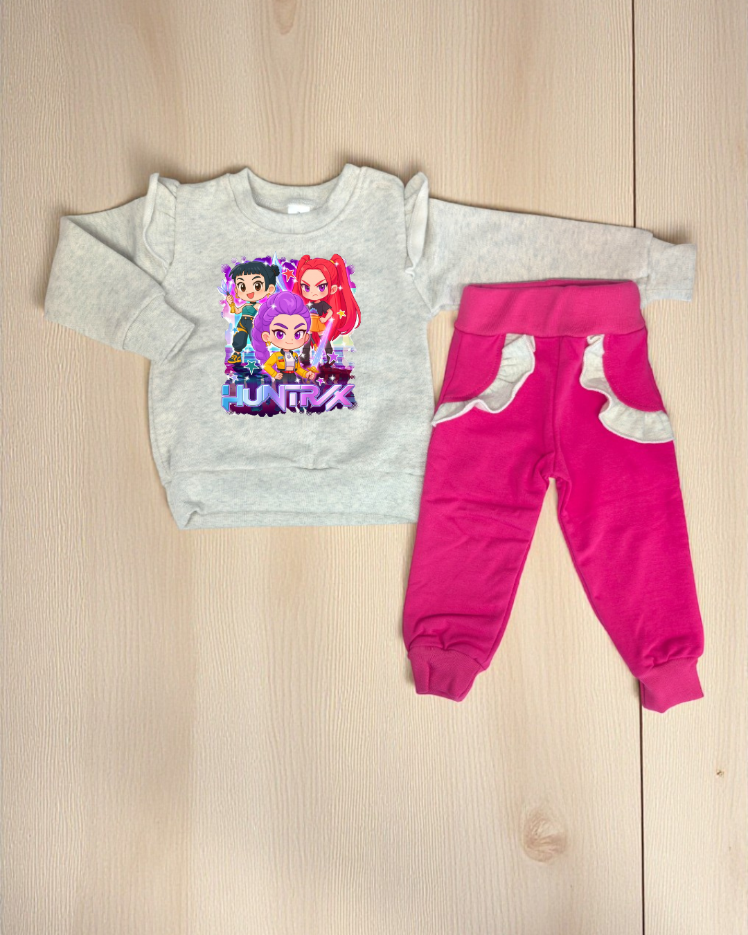 Conjunto de roupa colorido para criança sobre superfície de madeira clara