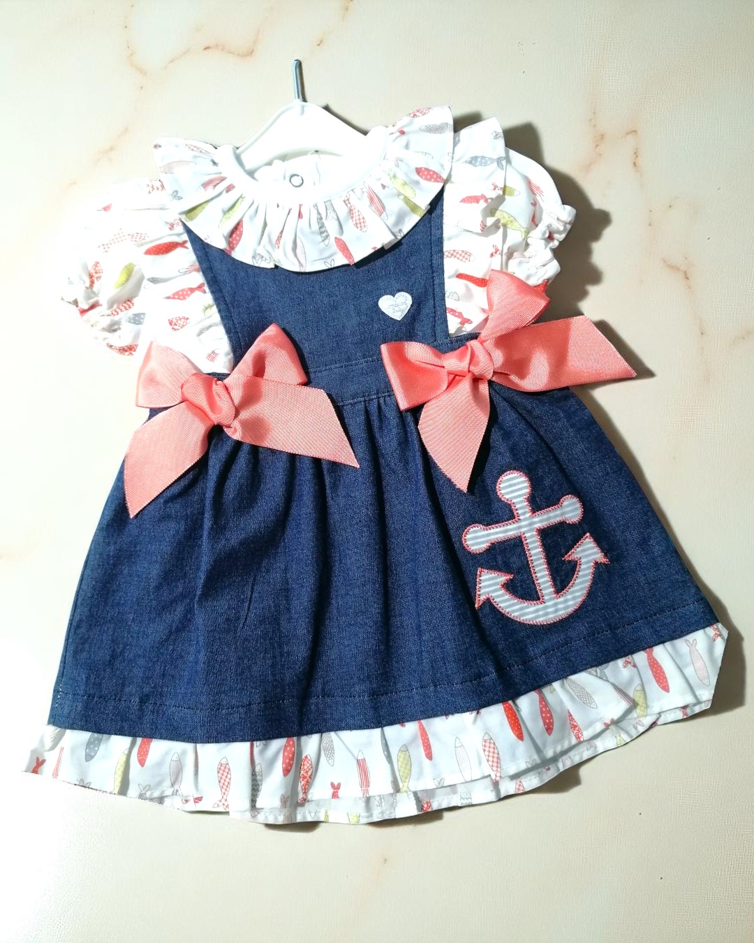 Vestido de bebé azul com laços cor-de-rosa e estampado colorido de peixes e âncora
