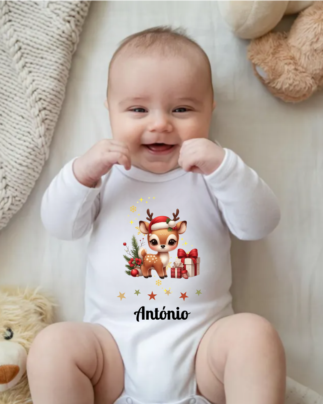Bebé a usar body branco com estampa de rena de Natal e texto António